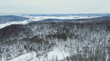 Sabahın erken saatlerinde, yuvarlanan tepeleri kaplayan kar manzarası.