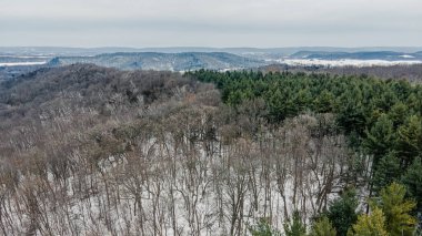 Sabahın erken saatlerinde, yuvarlanan tepeleri kaplayan kar manzarası.