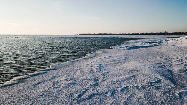 冬は太陽が昇るにつれて凍る海岸がある — ストック写真