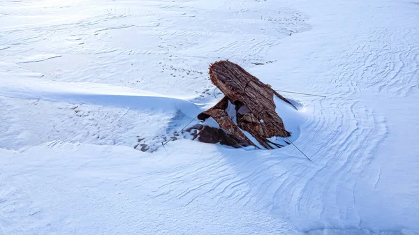 この崩壊した氷の釣り小屋を湖で覆う雪のドリフト — ストック写真