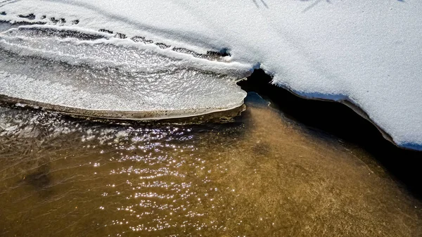 氷と雪が溶け水が動く小さな流れ — ストック写真