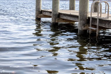 Sudan yansıyan güçlü bir yansıma ve üzerinde eski bir iskele var.