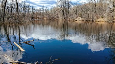 Ağaçlar hala çıplak. Su artık donmuş değil. Ve gökyüzü su yüzeyine yansıyor..