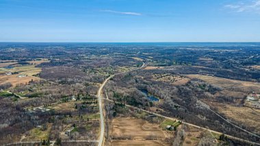 Ufukta, üzerinde sakin mavi bir gökyüzü olan ilkbahar manzarası. Kış geçtikçe baharın işaretleri her yerde.