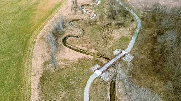 Spiraling River Follows Trail Spring Snow Has Melted Bridge Extends — Stock fotografie