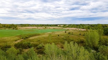 Bahar geldi ve kıştan sonra yeşiller geri dönüyor. Aşağıdaki çayır ve arazinin açık bir görüntüsü.