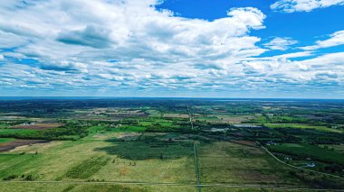 Baharda Wisconsin 'in kırsal kesimlerinde Tarım Tarlaları, Çayırları ve Ufuk Çayırları Bulutlu Mavi Gökyüzü Altında