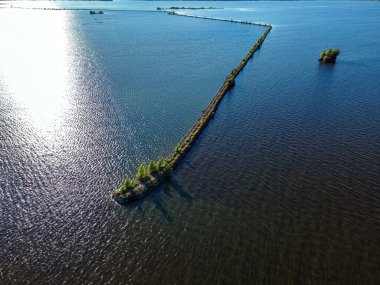 A desolate view as the sun shines brightly over the Fox River with a view of the breakwall near Oshkosh