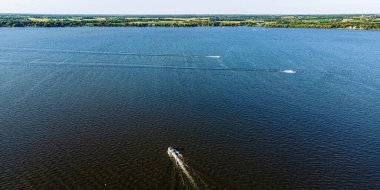 Its summertime and the boats cross the Fox River near Oshkosh Wisconsin.