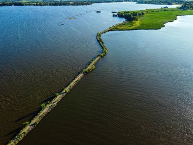 A desolate view as the sun shines brightly over the Fox River with a view of the breakwall near Oshkosh