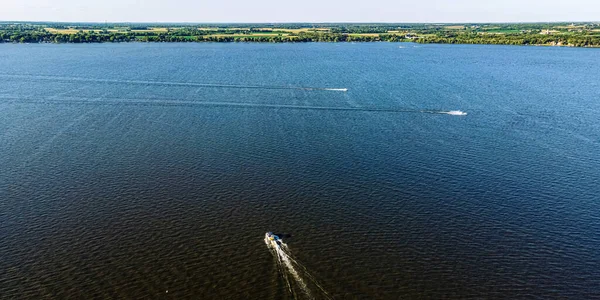 Its summertime and the boats cross the Fox River near Oshkosh Wisconsin.