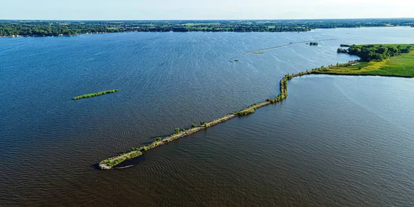 A desolate view as the sun shines brightly over the Fox River with a view of the breakwall near Oshkosh