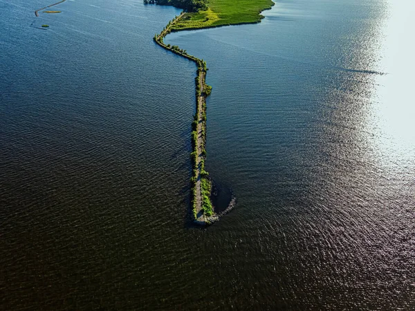 A desolate view as the sun shines brightly over the Fox River with a view of the breakwall near Oshkosh
