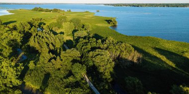 Near oshkosh wisconsin, a trail leads out to the brekawall on the fox river during the summer
