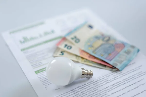 a light bulb and euro banknotes on an electricity bill. Increase in the cost of electricity for residential customers and business users. Payment of electricity bills. Increasing the concept of electricity prices.