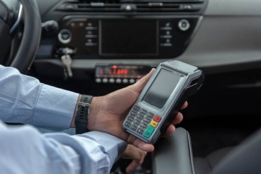 Kredi kartı ödemelerini işlemek için banka ödeme terminali tutan tanınmayan taksi şoförü - ulaşım konsepti, taksi, taksi ve teknoloji