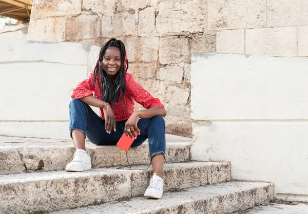 Leende Ung Afrikansk Amerikansk Kvinna Med Flätor Röd Skjorta Sitter — Stockfoto