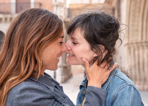 close-up of a young lesbian couple on the street kissing, gay concept