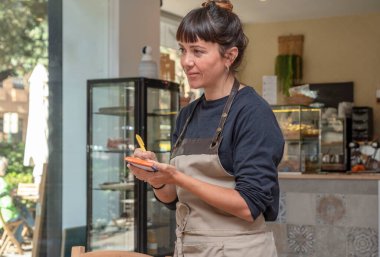 Müşteri siparişi alan genç bir garson.