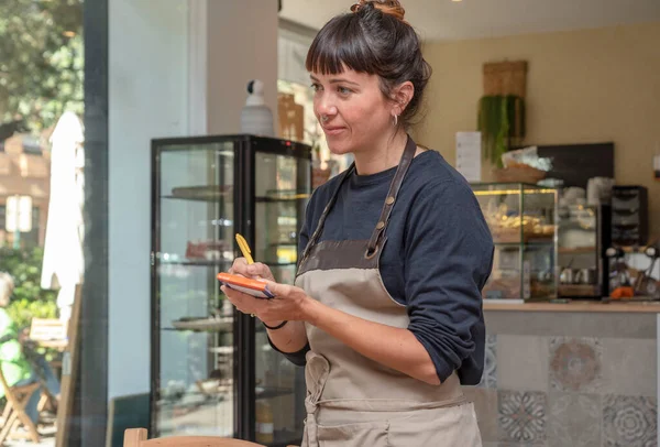 Müşteri siparişi alan genç bir garson.