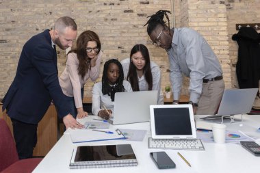 Genç bir Afrikalı Amerikalı girişimci, yönetim kurulunda çok ırklı iş arkadaşlarıyla birlikte projeleriyle ilgili yeni fikirleri ve stratejileri tartışıyor.