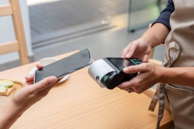 Bir bardaki ya da kafeteryadaki garsonun elindeki ödeme terminali üzerinden mobil bir uygulama ile ödeme yapmak.