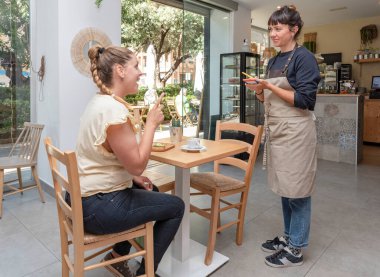 Kafeteryada ya da barda müşteriden sipariş alan genç bir garson.