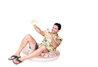 Plaj tişörtlü gülümseyen genç bir turistin portresi şişme şamandıranın üzerinde oturmuş kokteylinin fotoğrafını çekiyor. Turizm ve tatil kavramı