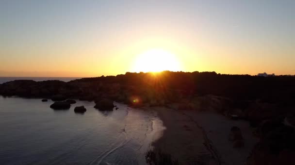 Tramonto aereo drone cielo. Il sole tramonta sulla silhouette delle montagne. Spiaggia vuota. — Video Stock