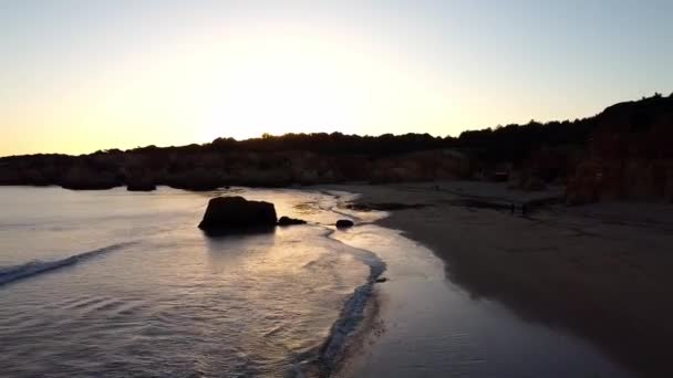 岩場の海岸線とシルエットの夕日。空のビーチ。シネマティックドローン撮影 — ストック動画