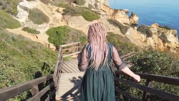 Donna al rallentatore che scende dalle scale. Spiaggia turchese, onde dell'oceano. — Video Stock