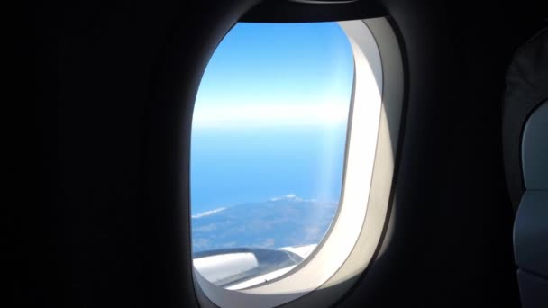Mirando por la ventana mientras vuela con avión.Pocos tiempo nublado con cielo azul. — Vídeo de stock