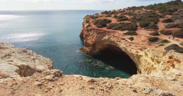 Прекрасний морський ландшафт Алгарве, відома печера Бенагіль на задньому плані, хвилі спокійно, глибокий синій океан. Прекрасний португальський пляж з золотими скелями, великими піщаними скелями. Концепція свята — стокове відео