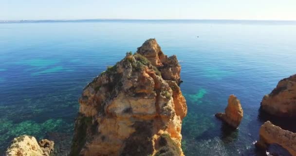 Olhando de um ponto de vista da direita para a esquerda sobre o oceano azul profundo sem fim. No topo do miradouro da colina. Grandes calcários amarelos na água. Falésias e rochas. Conceito de férias e viagens — Vídeo de Stock