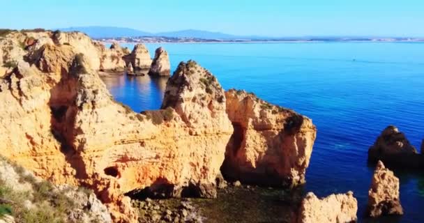 Overlooking magnificent limestone coast with blue turquoise ocean. Mountains on the background. Yellow and orange rocks cliffs in the ocean. Famous destination. Background texture, wall inspiration — Stock Video