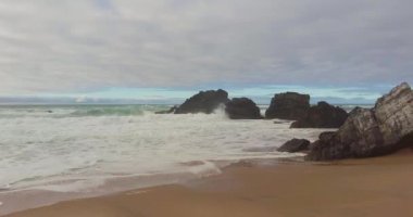 Kıyı şeridinde köpüklü dalgalar kopuyor. Mavi turkuaz dalga su dokusu.