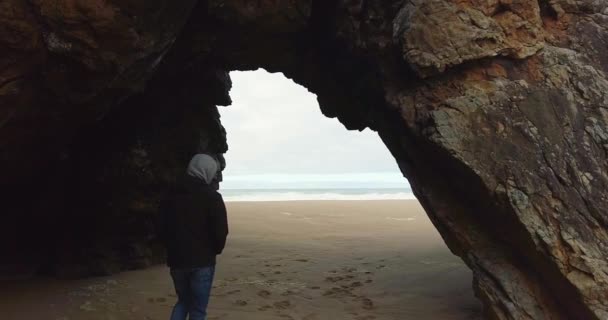 Male walking slow motion out of the cave to the ocean. Atlantic ocean — Stock Video