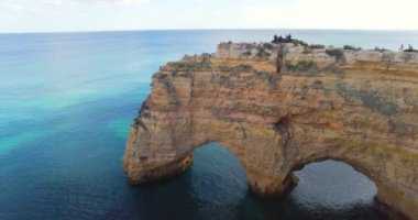 Donanma plajında Arco Natural. Portekiz, Algarve 'de çifte uçurum. Doğal kaya oluşumu, koyu mavi okyanus ve sarı kaya oluşumu. - Evet. Okyanusun üzerindeki doğal kemer.. 
