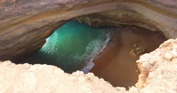 Bengáli barlang, emberek nélkül. Óceán a barlangban. Algarve, Portugália. Bengáli barlang Caroveiro-ban. Nézd meg egy lyukon keresztül a mennyezeten. Kő alakzat. Mélykék átlátszó óceán a barlangban. — Stock videók