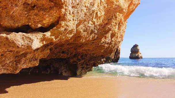 Вода медленно приближается к скалистому побережью. Прозрачная вода свободно перемещается — стоковое видео