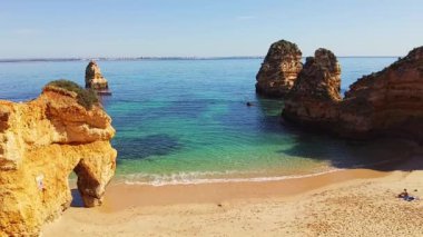 Praia da Boneca 'da. Tropikal bir sahil manzarası yavaşladı. Okyanusun içinde kireçtaşı kemerleri. Kaya oluşumları ve mavi yeşil şeffaf su. Boş sahil, insan yok. Yazın tadını çıkarıyorum.. 