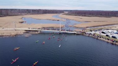Bird eye view of canoers kayakers going over the bridge. Pro athlete competition