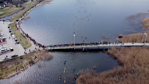 Drone shot of people standing on a bridge and encoureging sport athletes. Kayak — Vídeos de Stock