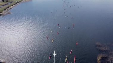 Birds eye view of people standing on a bridge and encouraging canoers 