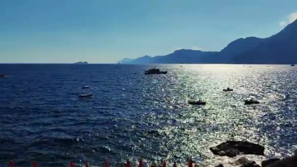 俯瞰美丽的大海 背后是群山 人们与木板一起游泳 享受夏天和阳光 深蓝色的山和深蓝色的海 高质量的4K镜头 — 图库视频影像