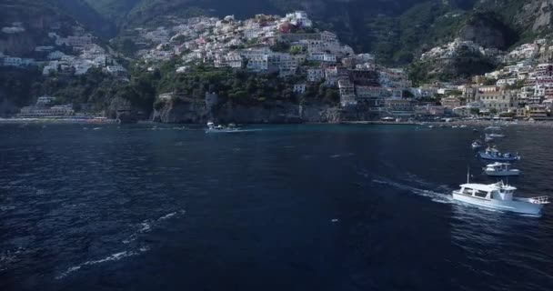 美しいポジターノの空中ビュー ナポリ イタリアを飛んでいます アマルフィ海岸沿いの白い町 ボートが動いて浮かんでいる白いビーチと青い海の高い景色 街を飛び越える — ストック動画