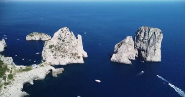 İtalya, Capri 'deki Tyrhenian deniz kıyılarının insansız hava aracı görüntüleri. Güzel kayalık uçurumlar, şeffaf mavi sular, hareket eden ve yüzen tekneler, okyanusun içindeki dağlar. Önemli turistik merkezler 