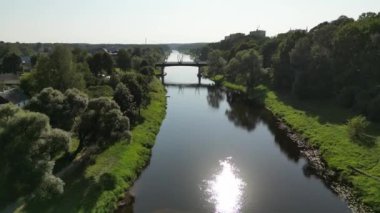 Şehrin içinde nehir ve köprü üzerinde uçuyor. Valmiera, Letonya. Nehir ve eşsiz köprüsü olan güzel bir yaz manzarası. - Evet. Yüksek kalite 4k görüntü