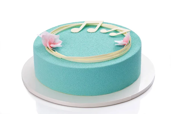 chocolate mousse cake on a white background, decorated with flowers and notes of white chocolate. Close-up view. Turquoise mousse cake.