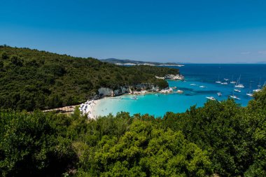 A crystal clear waters from the small wooden pier in the Voutoumi beach in the island of Antipaxoi, Ionian islands, Greece